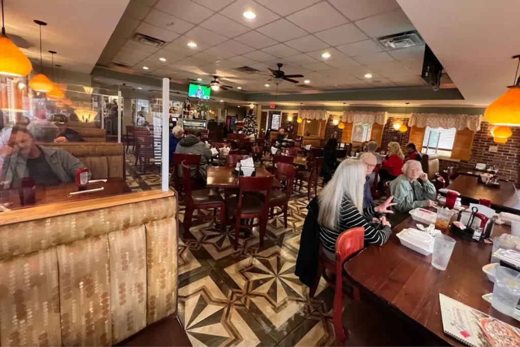 Busy Italian restaurant dining room with customers seated.